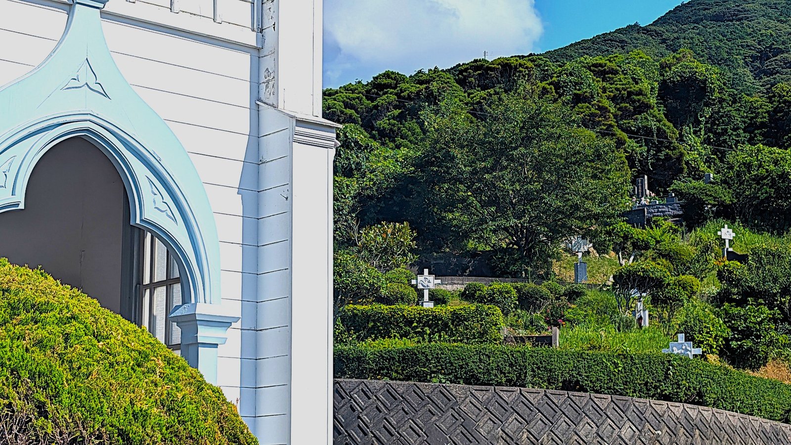 Uploaded photo of an island church beside hillside crosses