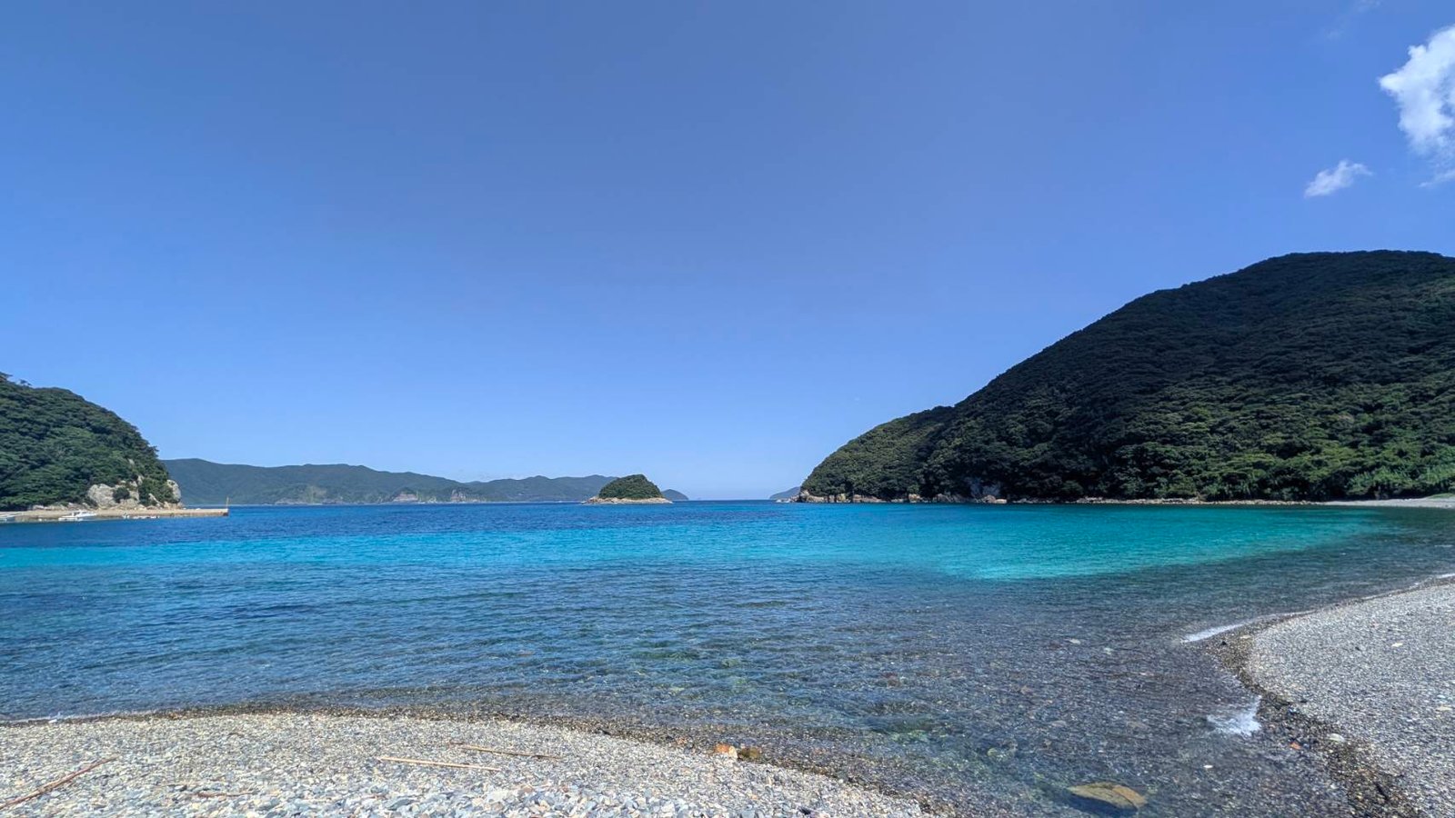 A quiet Goto beach with clear blue water and green hills
