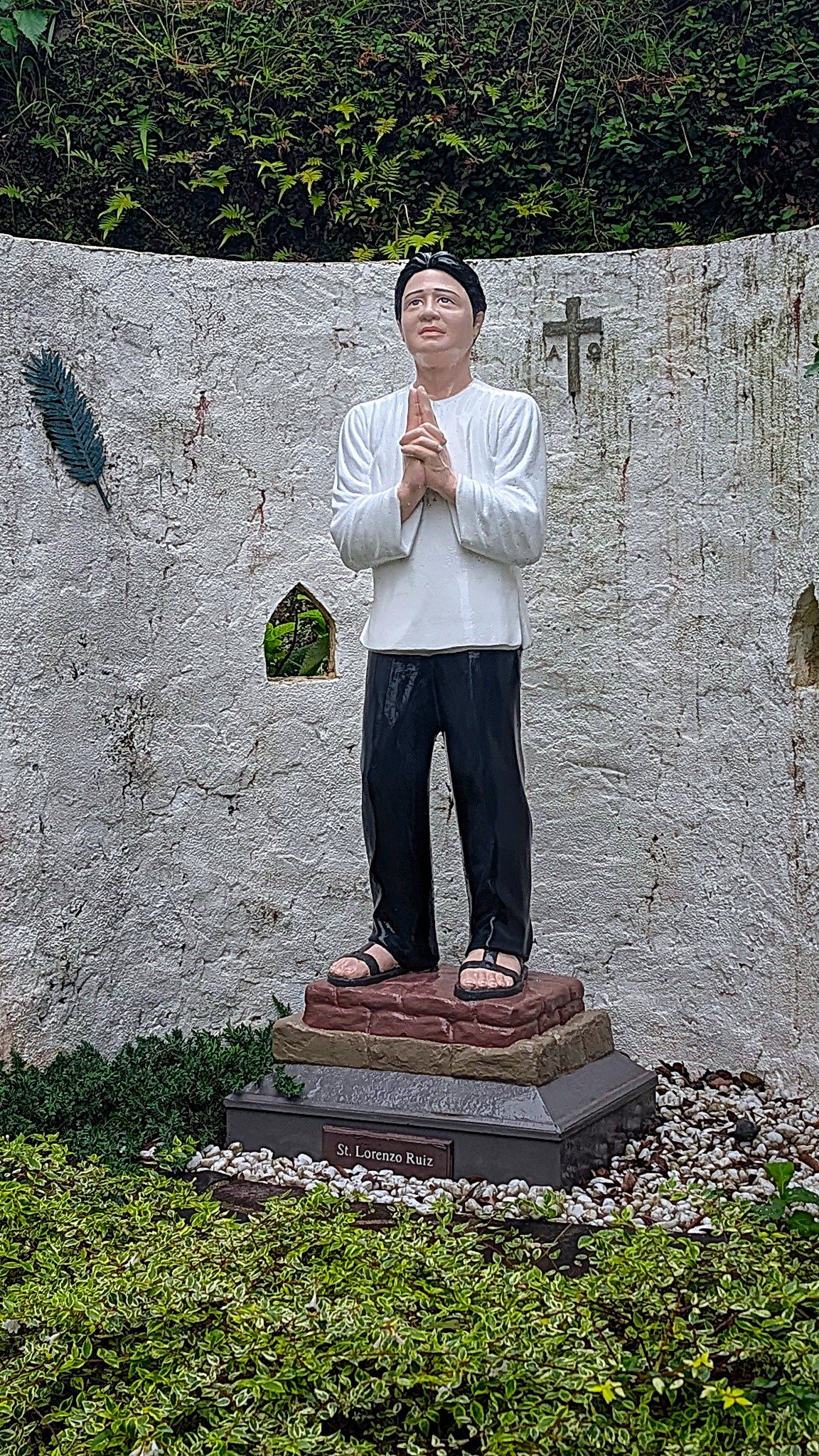 Statue of Saint Lorenzo Ruiz with his face and hands raised in prayer